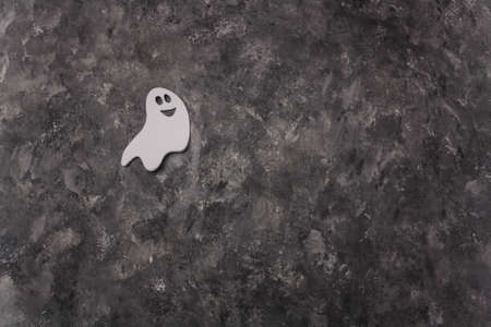 Smiling white ghost shaped Halloween sticker on gray painted background, Halloween card template, copy spaceの写真素材