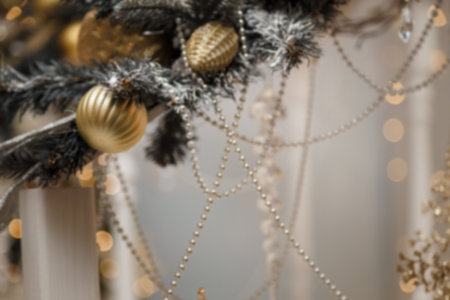 Unfocused shot of fir branches on festive Merry Christmas and Happy New Year background. Warm golden...