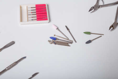 Set of disinfected manicure or pedicure tools. Cuticle pushers, cutters set and tweezers for safe hygiene, beauty and nails care. Top view. Place for textのeditorial素材