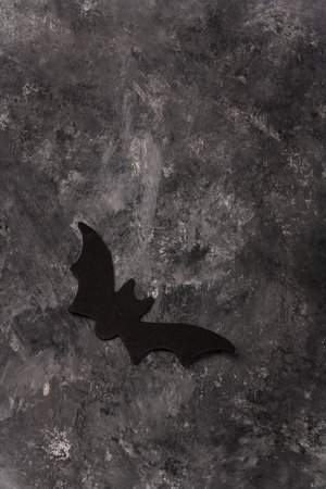 Scary Halloween black flying bat sticker on gray background. Happy Halloweed frame holiday card, copy space, vertical shotの写真素材