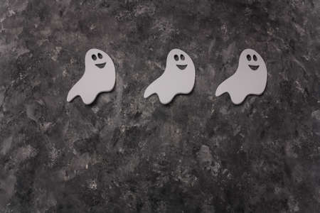 Three Halloween white ghosts shape stickers on gray background. Halloween frame card, copy spaceの写真素材