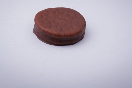One chocolate bisquit cookie on light background. Sugar, sweet food, tasty dessert. Copy spaceの写真素材