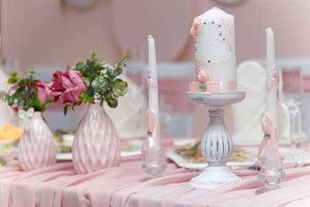 Beautiful white candles with pink decorative elements, roses and heart for just married wedding presidium or Valentines day decor for romantic dinner.の写真素材