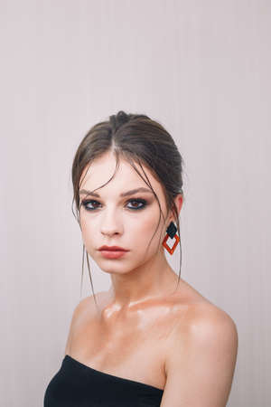 Beautiful teenage girl model with professional make-up and hairstyle posing for camera. Beauty portrait of female teenager with visage. Cosmetics, beauty standards, skin care concept. Close up shot.の写真素材