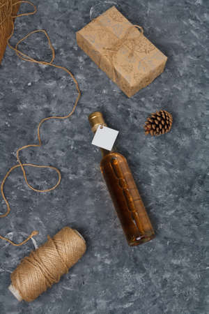 Wrapped Christmas gift box, 250 ml bottle of white wine with blank label. Merry Christmas alcohol drink for present. Vertical shotの写真素材