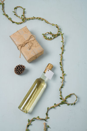 Wrapped Christmas gift box, 250 ml bottle of white wine with blank label. Merry Christmas alcohol drink for present. Vertical shotの写真素材