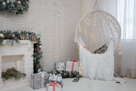 Beautiful white lace cocoon chair with plaid and cushion, golden garland lights in room decorated...