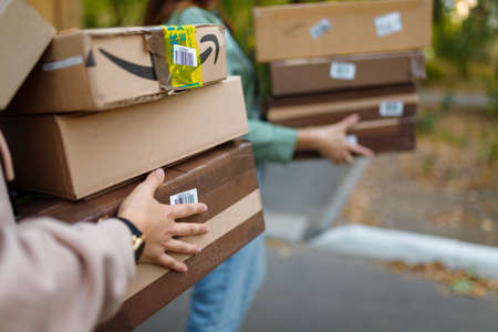 Izmail, Ukraine. May 2021. Women carrying many cartons, parcels, packages. Close up, only hands visible.のeditorial素材