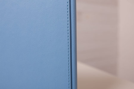 Spine of book, photobook, notebook or photoalbum in light blue leather cover on white background.