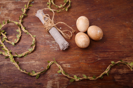 Brown Easter eggs on rustic table, colored with coffee. Happy Easter concept, top view.