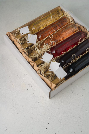 Assortment of 250 ml bottles of red, pink, white wine in box of wooden shavings, no label. Set of alcohol drinks for present or celebrationの写真素材