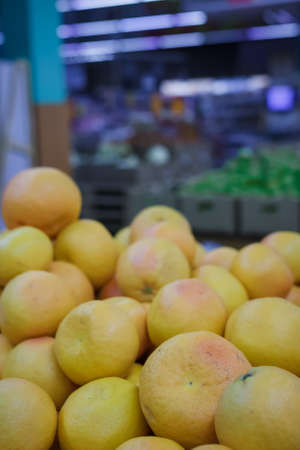 Exotic citrus fruit in supermarket or grocery store, shop. Heap of oranges on counterの写真素材
