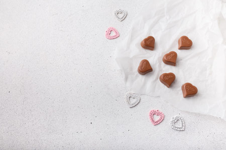 Izmail, Ukraine. 14 February 2022. Heart shaped chocolates Milka, plastic toys on white paper...