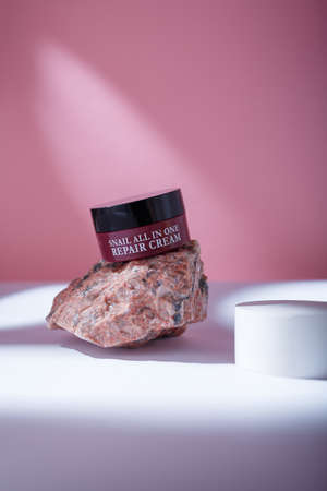 Izmail, Ukraine. May 2022. Brown container of korean Eyenlip Snail All In One Repair Cream on pink backdrop, Korean anti-aging care cosmeticsのeditorial素材