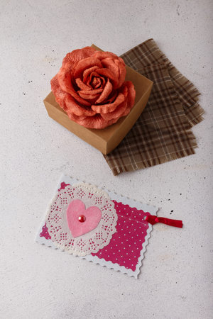 Brown paper present box, fabric rose flower, postcard with pink heart on white background....