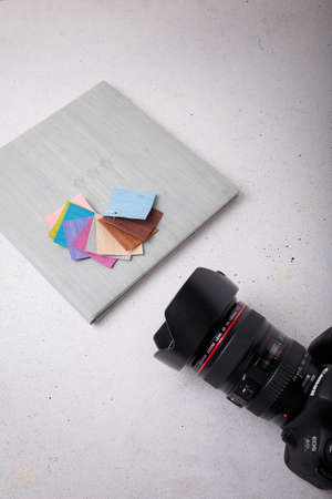 Izmail, Ukraine. April 2022. Canon EOS photo camera with L series zoom lens, album with grey leather cover samples on white background, copy spaceのeditorial素材