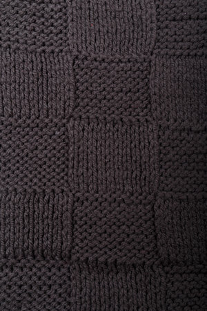 Check or checkerboard knitted grey fabric texture. Textile, scarf or sweater textured background. Warm accessories, clothing, fashion conceptの写真素材