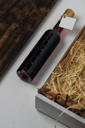 250 ml bottle of red wine with blank label. Cabernet sauvignon, merlot, pinot noir. Box with wooden...