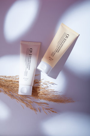 Izmail, Ukraine. May 2022. Esthetic bright complex intense nourishing hair conditioner and shampoo on white background, harsh shadowsのeditorial素材