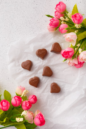 Izmail, Ukraine. 14 February 2022. Heart shaped chocolates Milka, bright flowers on white paper. Valentines day sweetsのeditorial素材