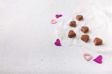 Izmail, Ukraine. 14 February 2022. Heart shaped chocolates Milka, plastic toys on white paper background. Valentines day sweetsのeditorial素材