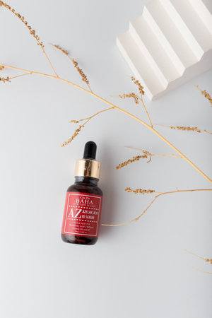 Izmail, Ukraine. March 2022. Baha cosmetics. Brown bottle of azelaic acid on white background with geometric concrete decorative element. Skin careのeditorial素材