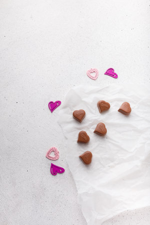 Izmail, Ukraine. 14 February 2022. Heart shaped chocolates Milka, plastic toys on white paper background. Valentines day sweetsのeditorial素材