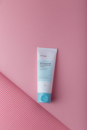 Izmail, Ukraine. March 2022. IUNIK Beta-glucan daily moisture cream, brightening and wrinkle care. Skin Korean cosmetics. Tube on pinkのeditorial素材