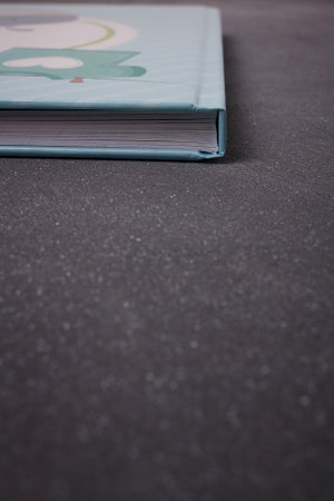 Izmail, Ukraine. June 2020. Baby boy blue photo album or photobook on grey background. Spine and sheets sideways. Copy spaceのeditorial素材