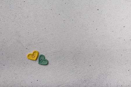 Two decorative heart-shaped buttons on white background. Ornamental details for sewing, scrapbooking, handmadeの写真素材