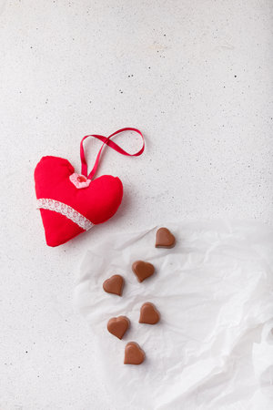 14 February Heart shaped chocolates, fabric heart toy on white paper. Valentines day sweets and presentsの写真素材