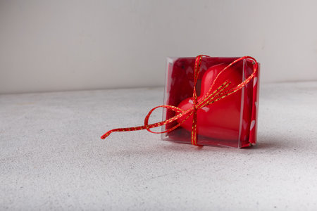 Red heart-shaped candle in box on white background. Small Valentines day present, symbol or souvenir. Copy spaceの写真素材