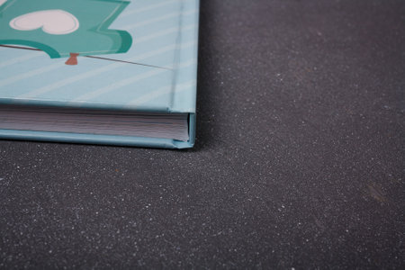 Izmail, Ukraine. June 2020. Baby boy blue photo album or photobook on grey background. Spine and sheets sideways. Copy spaceのeditorial素材