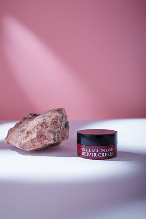 Izmail, Ukraine. May 2022. Brown container of korean Eyenlip Snail All In One Repair Cream on pink backdrop, Korean anti-aging care cosmeticsのeditorial素材