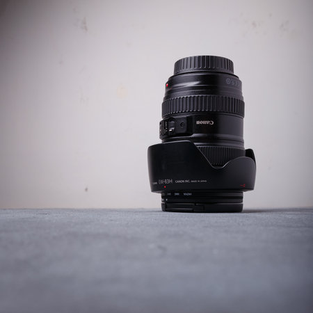 Izmail, Ukraine. April 2022. Photo camera lens for canon, L series with red ring on grey background. Square shot, copy spaceのeditorial素材