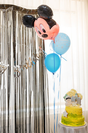 Izmail, Ukraine. May 2022. One year old baby boy birthday cake with toppers and number 1 gingerbread cookie. Blue balloons and Mickey Mouse head balloonのeditorial素材