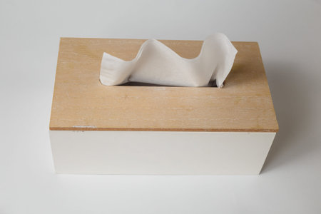 Wooden tissue box, container with facial wipes on white table background.