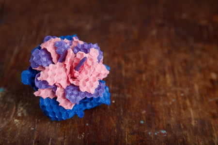 pink purple and blue textured candle in shape of a flower made from natural bee wax on old rustic wooden table background. closeup shot.の写真素材