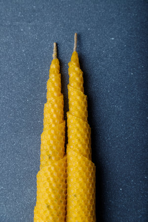 Two connected spiral cone candles made from natural wax on gray wooden background. Top view, copy space.の写真素材