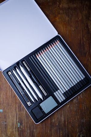 Metal box of art supplies. Set of graphite pencils, rubber, knife and kneaded eraser. Holder handle...