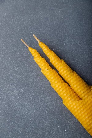 Two connected spiral cone candles made from natural wax on gray wooden background. Top view, copy space.の写真素材