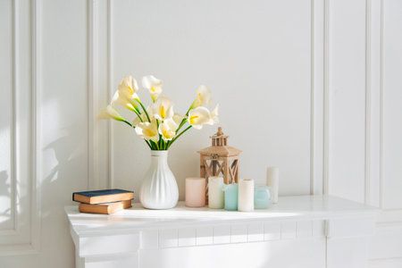 Soft home decor, white jug, vase with white and yellow beautiful flowers on a white wall background...