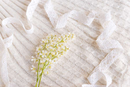 Lily-of-the-valley flowers on a white knitted backgroundの写真素材