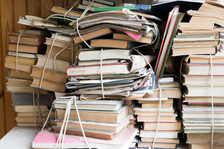 Pile of old books on shelf in library, closeup viewの写真素材