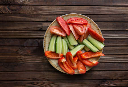 Cucumber, tomato and cucumber salad on wooden background.の写真素材