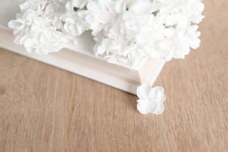 White artificial flowers on wooden table, closeup. Space for textの写真素材
