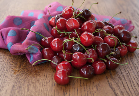 Cherry on a wooden background with bright fabric