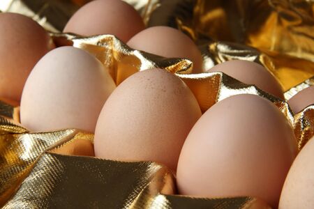 some fresh eggs in gold backgroundの写真素材