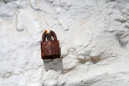 rusty padlock on old dirty white wallの写真素材