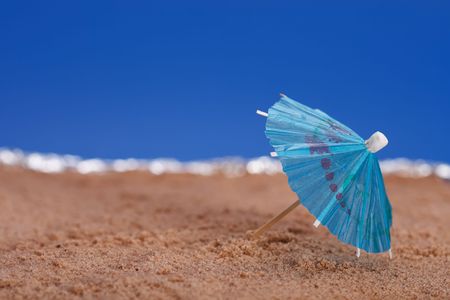 parasol on beach sand with sea and blue sky backgroundの写真素材